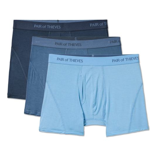 Three pairs of men's boxer briefs in blue and gray with 'Pair of Thieves' branding on a white background.